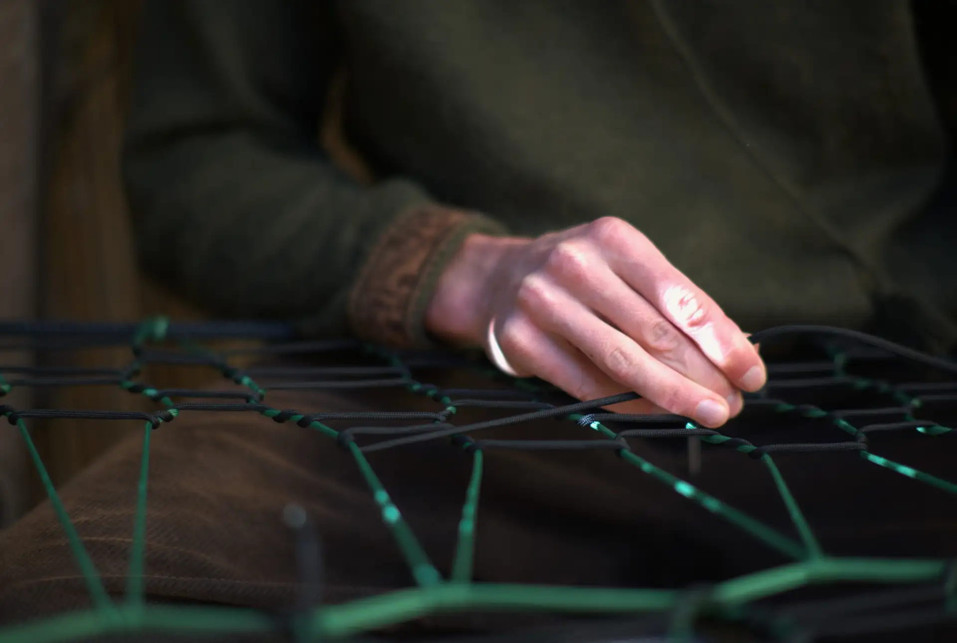 Main tissant une corde — artisanat BamBam Tree Nets, Toulon